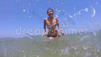年轻的混血女孩穿着比基尼用海水滴溅相机。 高清，1920x1080快慢动作。